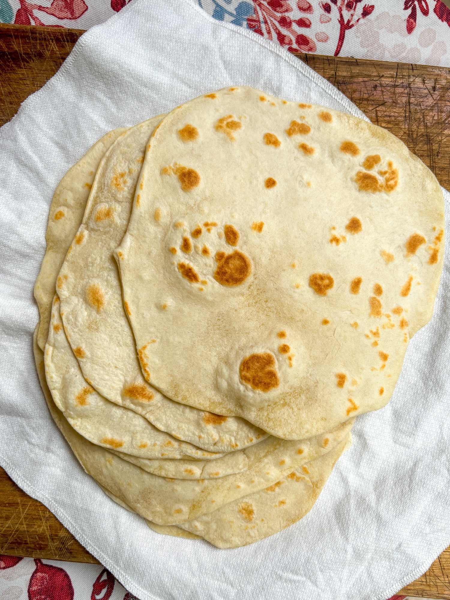 homemade flour tortillas on top of a white cloth